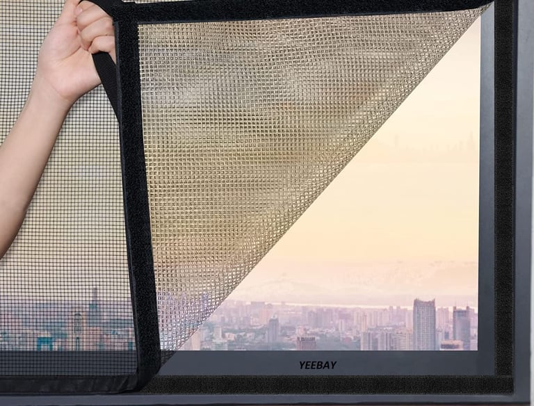 Installation team fitting a velcro type mosquito net on a residential window.