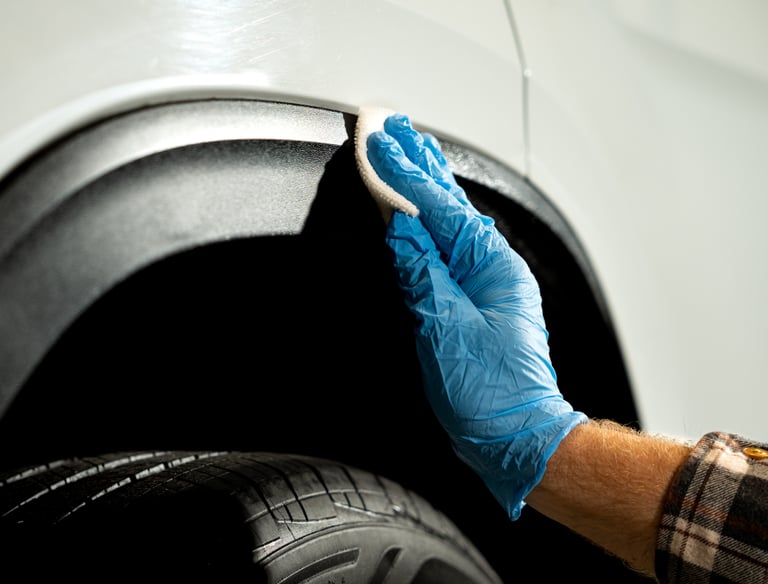 Professional car detailing applying plastic trim restorer to a white vehicle in Logan Ohio 