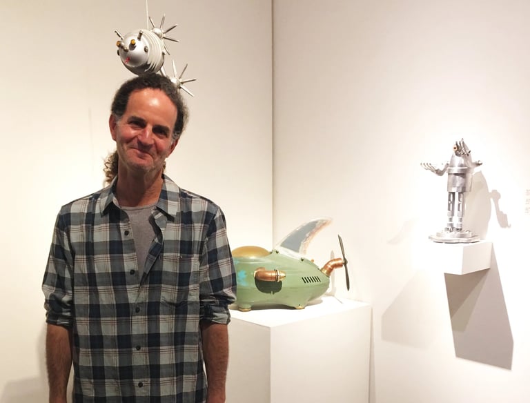 Photo of artist Tal Avitzur at a gallery showing of his art.