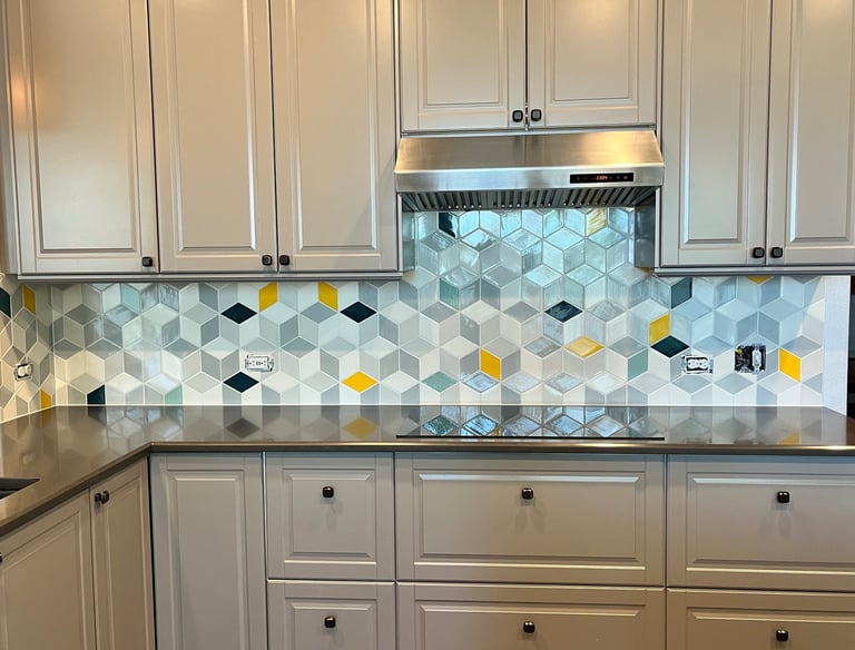 Modern kitchen with grey cabinets and a geometric hexagon tile backsplash featuring yellow accents.