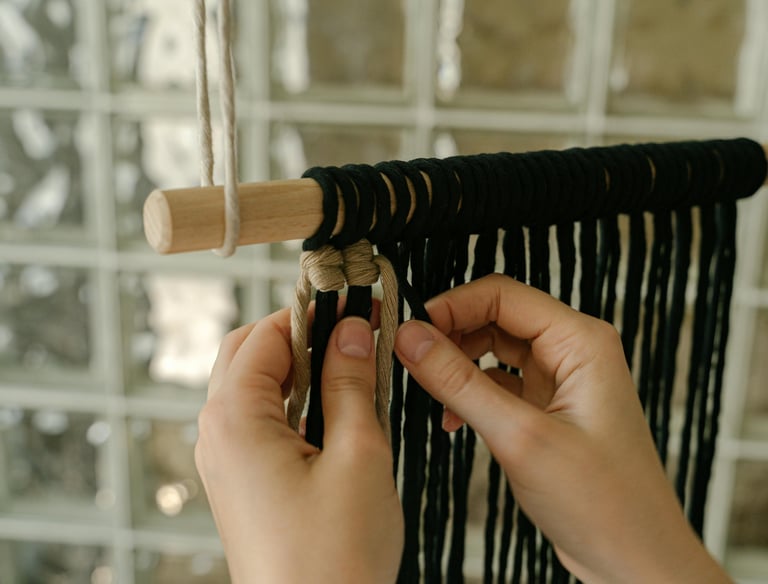 tejiendo macramé con un palo para colgar 