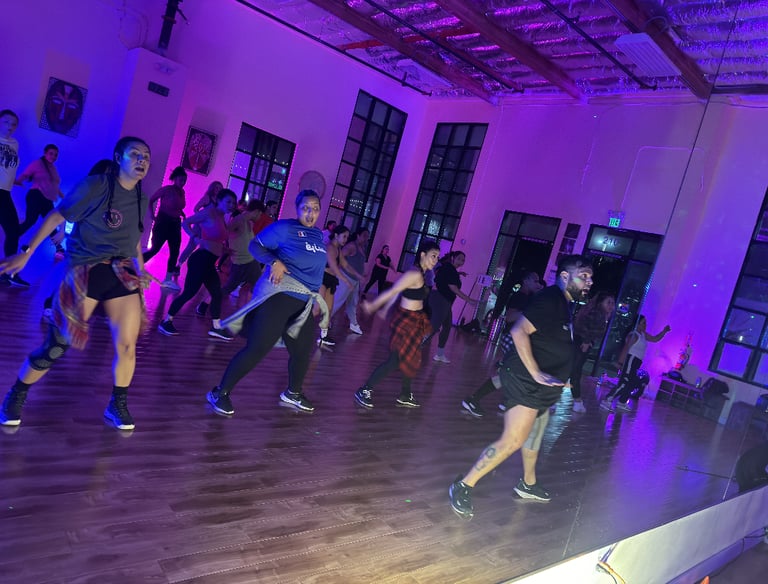 A group of 22 dancers actively posed in a dance move.