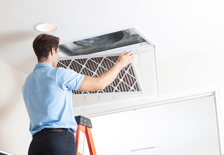 a man is standing on a ladder to get a picture of a man in a