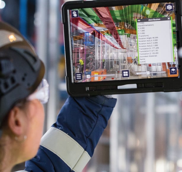 a woman in a helmet and safety glasses holding a tablet computer