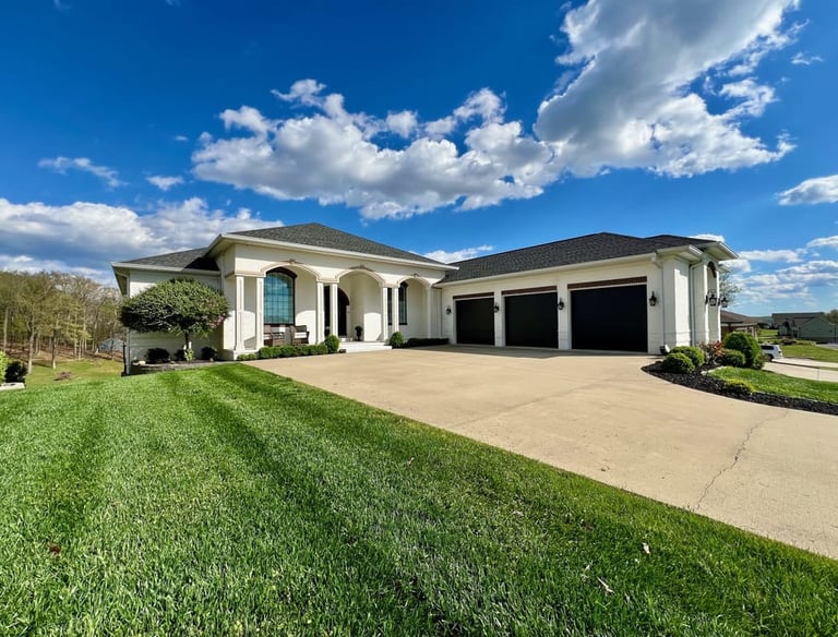An large white house with 3 car garage on a large lot