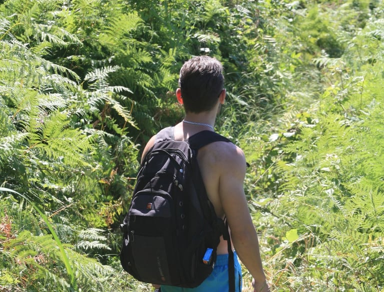 a man walking down a path with a backpack
