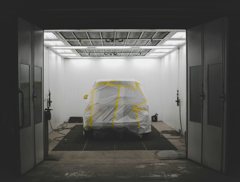 vehicle in a paint bay at a body shop, getting new auto paint repair