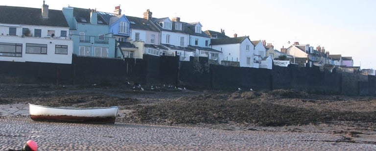 a boat sitting on the shore of a beach