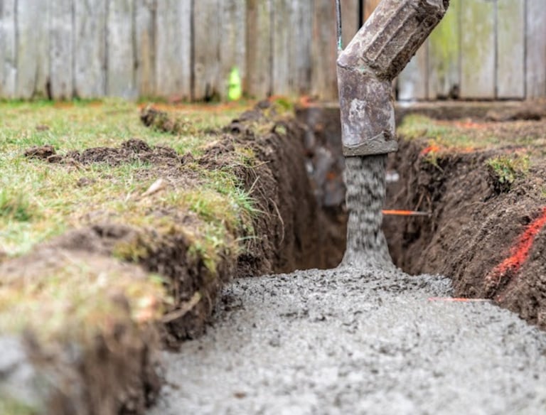 a concrete slab being poured into a concrete foundation