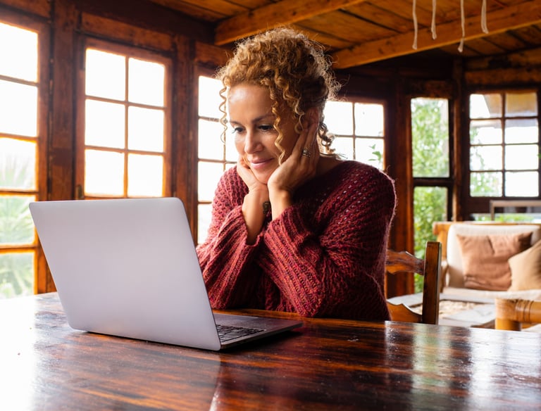 a woman sitting at a table with a laptop computer