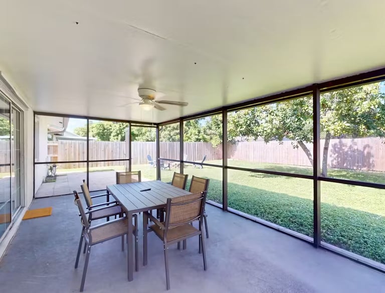 a patio with a table and chairs and a ceiling fan