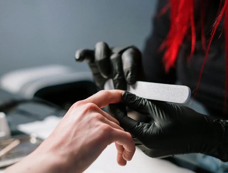 A manicurist in black gloves is doing a customer's nails.