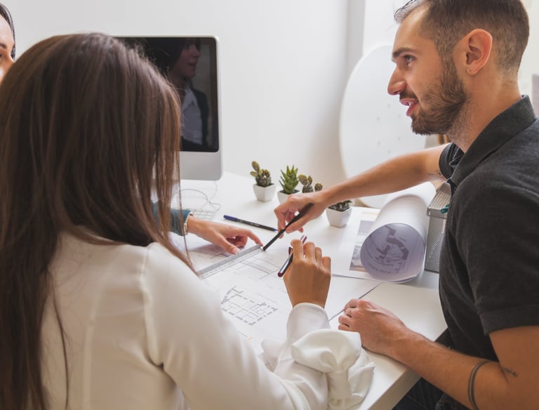 tres pessoas conversando e apontando para um projeto de arquitetura em folha impressa