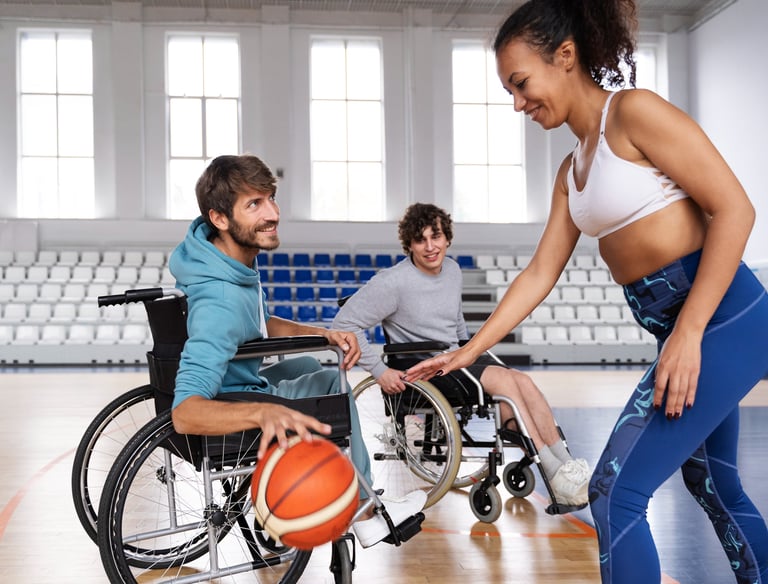 dois homens em cadeira de rodas e uma mulher em pe jogando basquete