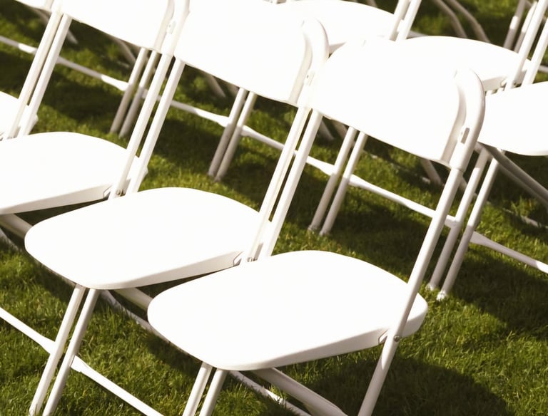 Sillas blancas plegables para eventos al aire libre en el paso