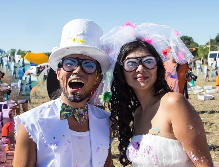 a man and woman in wild, zany white wedding attire