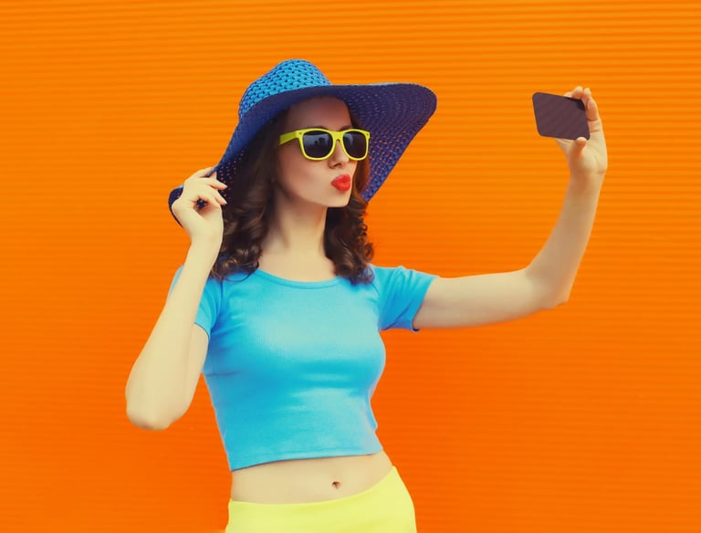 a woman in a blue top hat and sunglasses taking a selfie