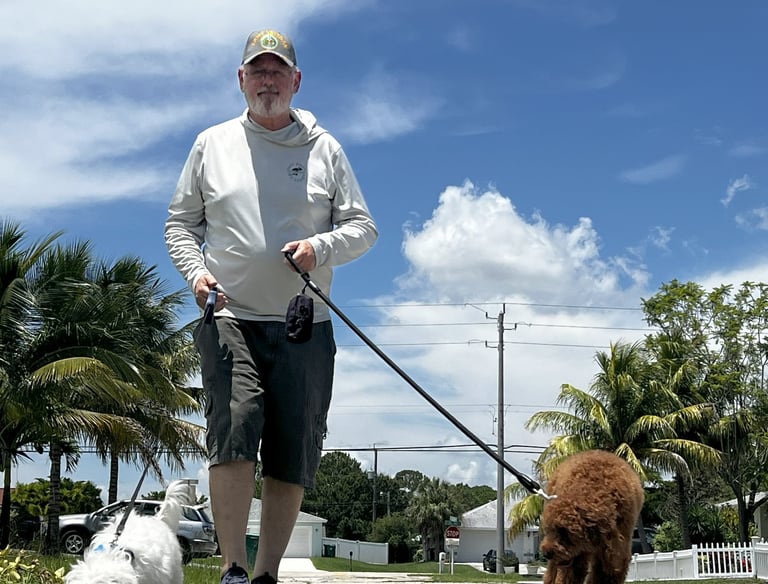 robert walking customers dogs in port saint lucie wearing a back's yard poop scooping shirt