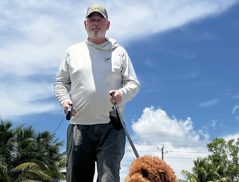 robert walking customers dogs in port saint lucie wearing a back's yard poop scooping shirt