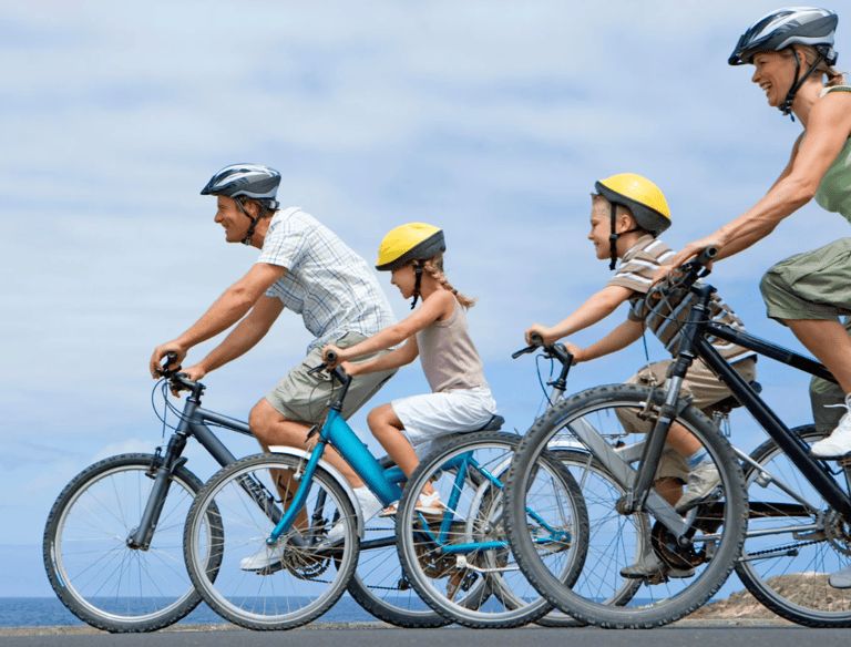 A family of four with two of them being children riding their bikes.