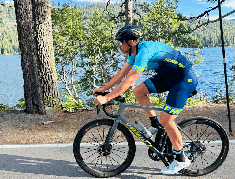 A man riding a bike next to a lake