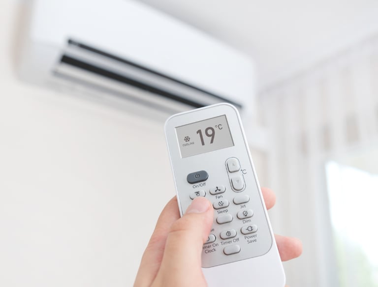 Una persona que enciende una unidad de aire acondicionado usando un control remoto