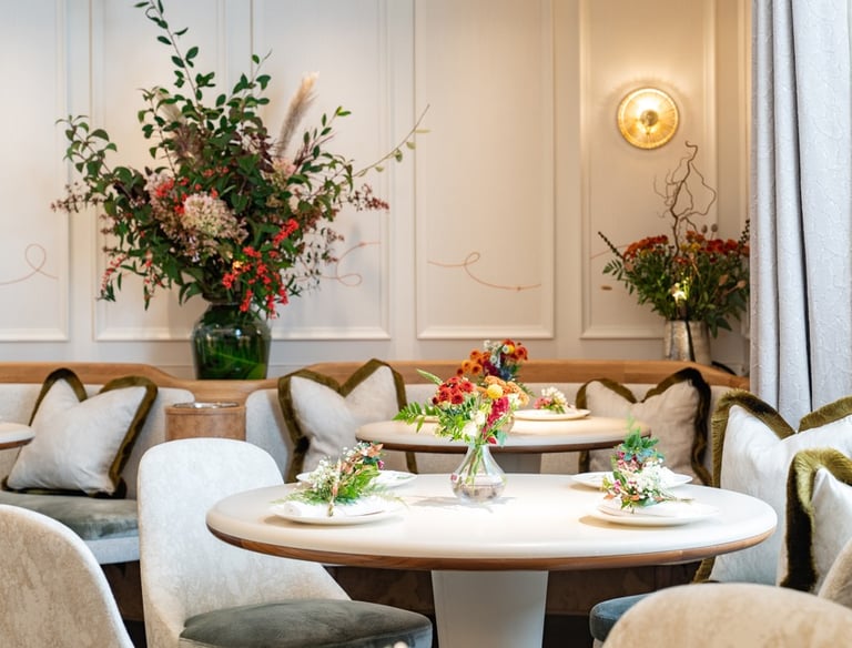Elegant dining space with floral arrangements and round tables.