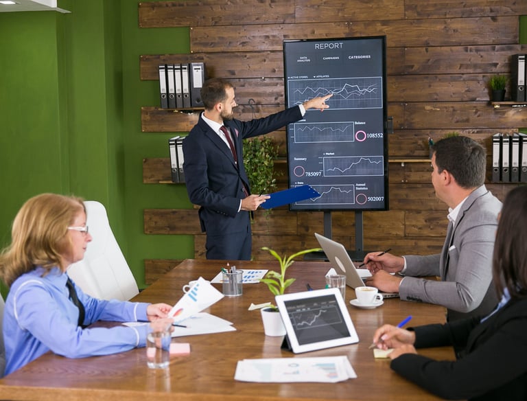 Man presenting a digital chart about Digital AI Marketing to his team in an office