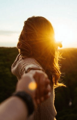 pareja en un campo agarrados de la mano felices despues de un amarre de amor efectivo