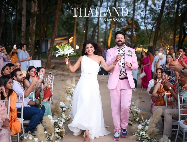 A happy bride and groom celebrate during a destination wedding ceremony in a tropical forest in Thailand.