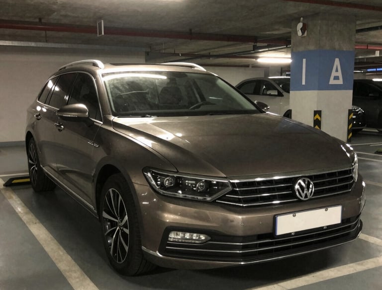 A sleek black sports car parked under soft lighting, highlighting its polished curves.