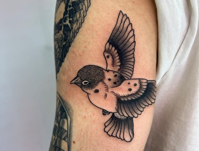 a bird tattoo on the arm of a man's arm