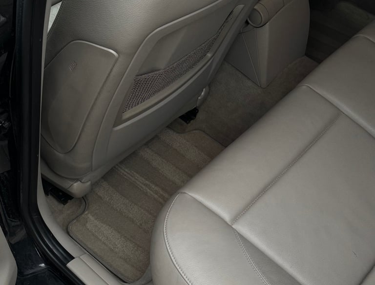 Švarus automobilio kilimėlis ir odinės galinės sėdynės po giluminio cheminio salono valymo – profesi