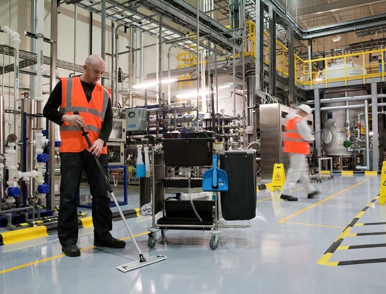 a man in a safety vest cleaning a floor