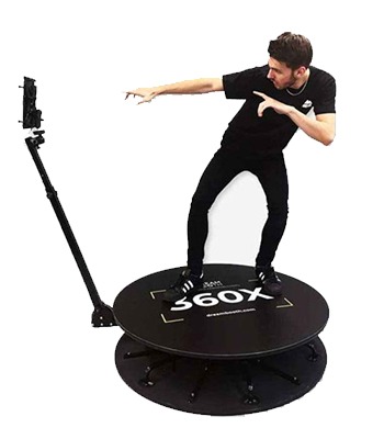 a man standing on a 360 photo booth with a camera