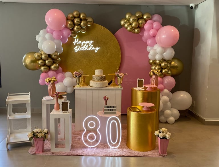 Decoração 80 anos rosa e dourado com arco de balões, painel elegante e mesa decorada Freguesia do Ó