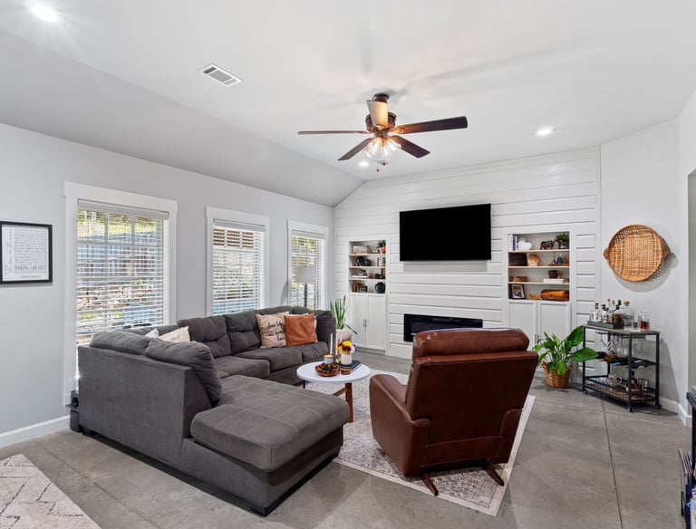 a living room with a couch and a ceiling fan