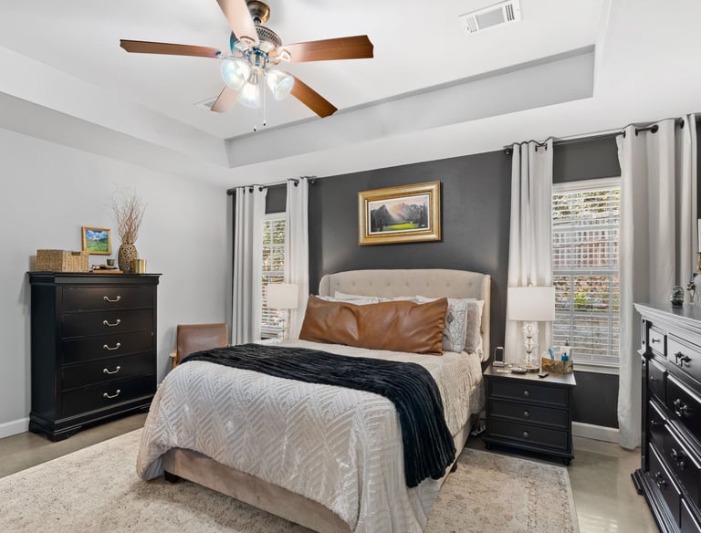 a bedroom with a bed and a ceiling fan