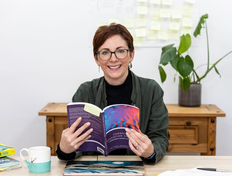 a woman is smiling and holding a book