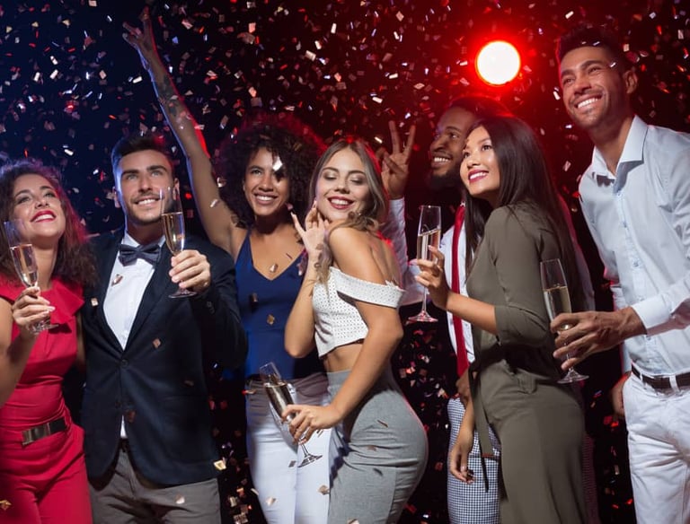 Group of friends enjoying a VIP nightclub crawl in Las Vegas with champagne and confetti.