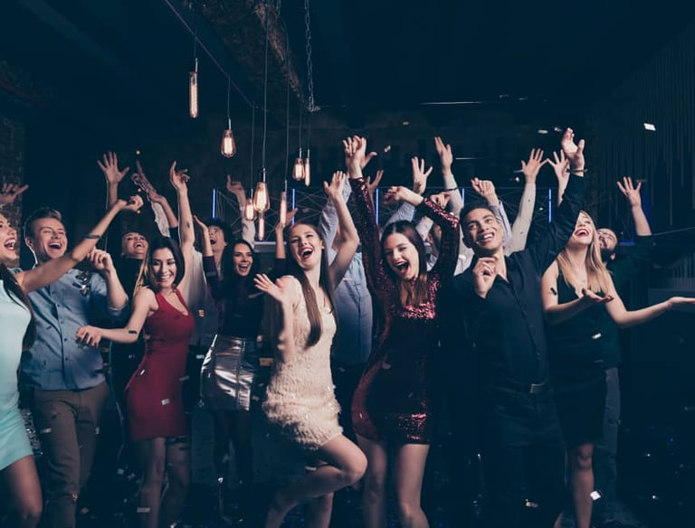 Group celebrating at a VIP private club crawl in Las Vegas with dancing and confetti.