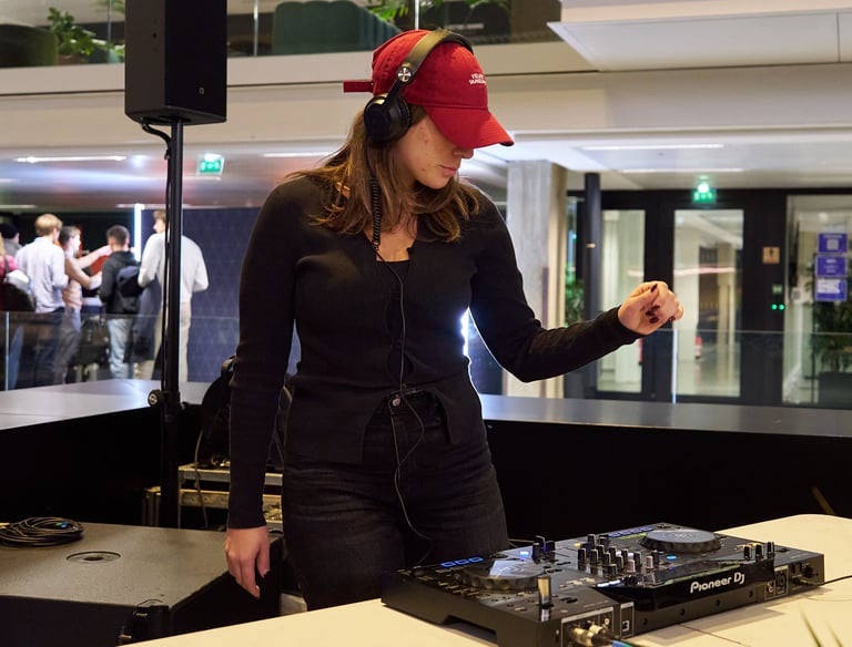DJ professionnel en pleine performance lors d'un cocktail d'événement corporate à Station F