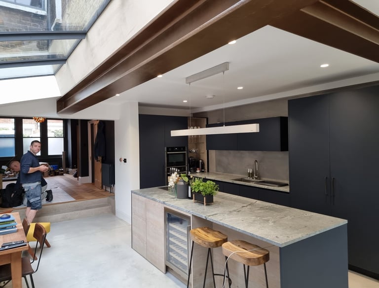 Modern kitchen in Balham with exposed beams and black cabinets, interior painting by Pure Perfection