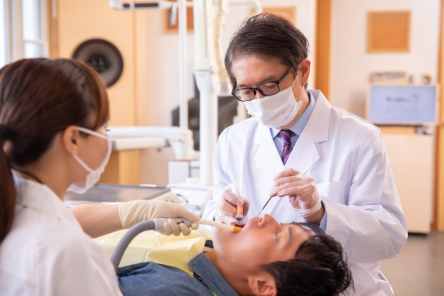 An image of a dentist, dentist assistant, and a patient.