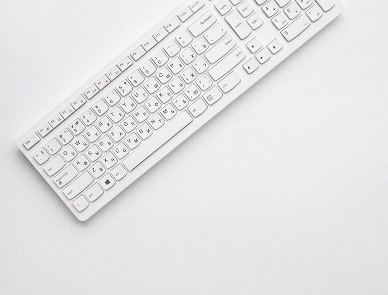 white corded computer keyboard on white surface