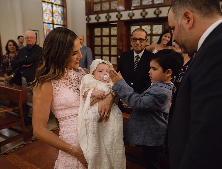 a man and woman holding a baby in a church