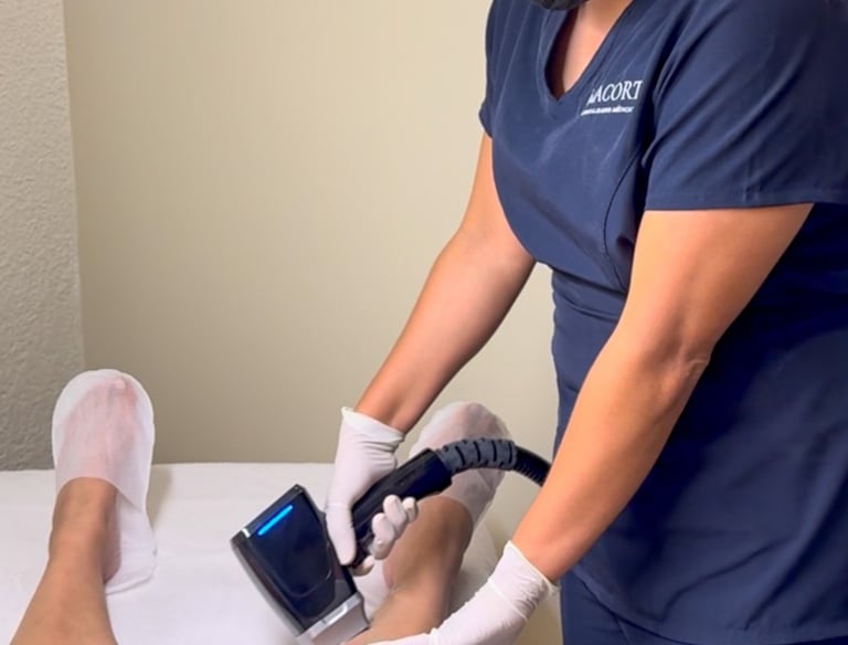 Professional technician performing laser hair removal treatment on a patient's leg at a medical spa.