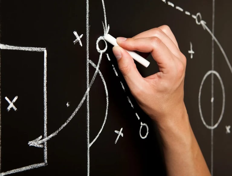 Hand diagraming a soccer play on a blackboard