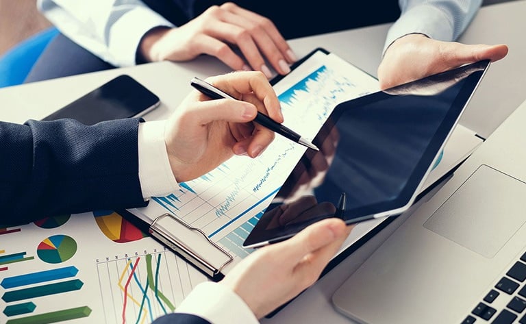 a man and woman working on a laptop computer