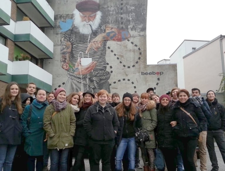 Group on street art tour in Hamburg in front of mural, Gruppe bei Street Art Tour vor Wandbild in Hamburg